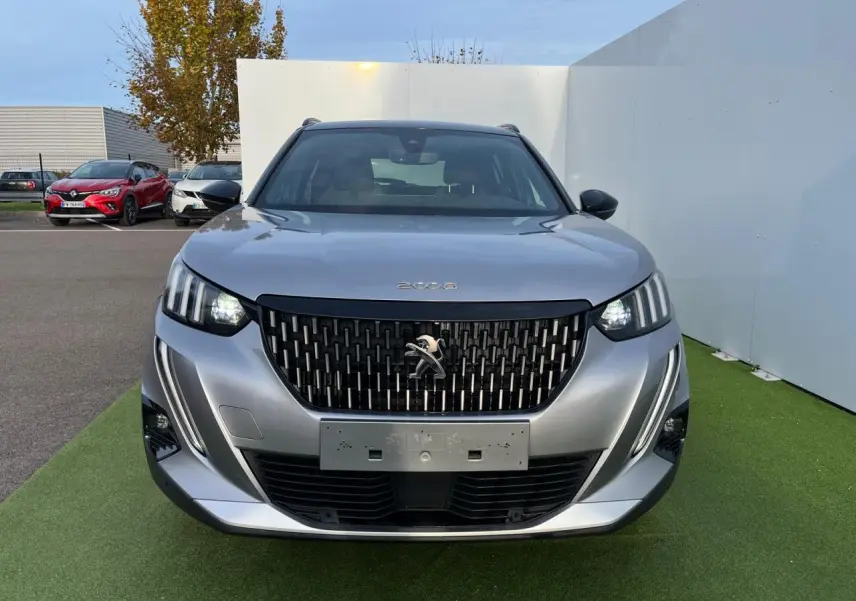 Vue de face du Peugeot 2008 gris Artense avec toit noir, feux LED et calandre noire distinctive.