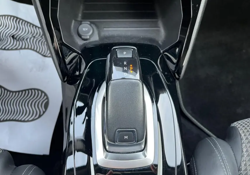 Le levier de vitesses automatique noir brillant de la Peugeot 2008 II vue en gros plan intérieur.