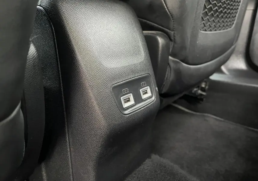 Prise USB double vue rapprochée à l'arrière des sièges noirs dans le Peugeot 2008 gris Artense toit noir.
