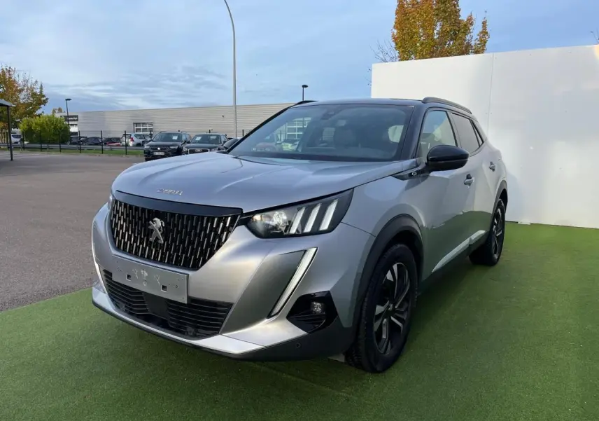 Peugeot 2008 gris Artense avec toit noir, vue 3/4 avant droit, jantes bi-tons et calandre distinctive noire.