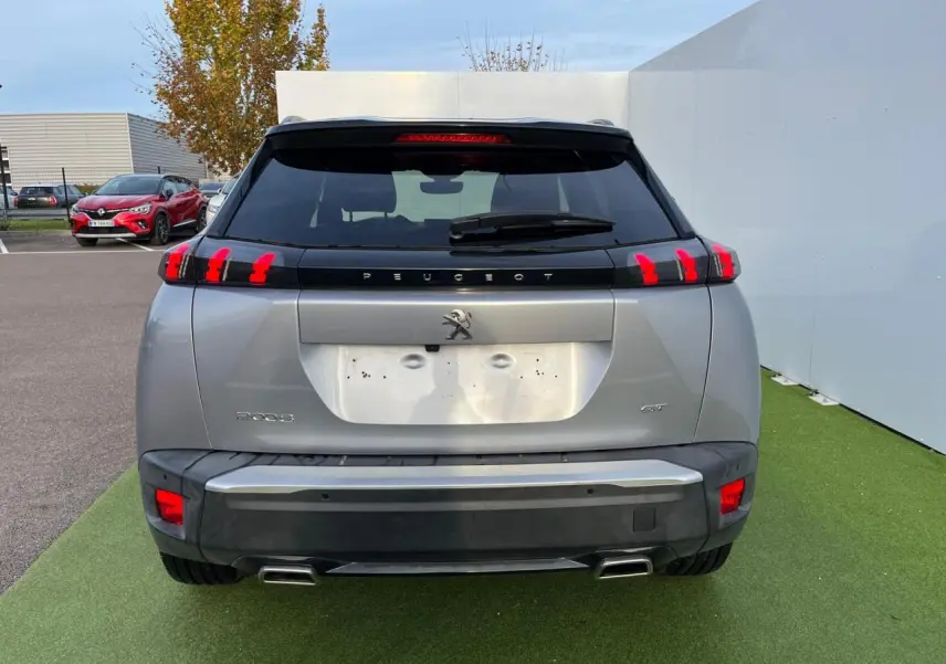 Vue arrière d'un Peugeot 2008 gris Artense avec toit noir et feux arrière à trois griffes LED visibles.