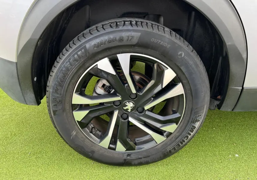 Gros plan sur la jante alliage 17'' bi-ton noir et argent du Peugeot 2008 gris Artense, détail du pneu Michelin.
