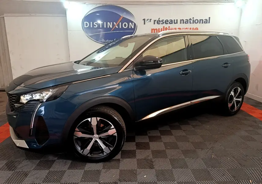 Peugeot 5008 PureTech 130 GT bleu en 3/4 avant droit, avec jantes alliage et détails chromés sur carrosserie