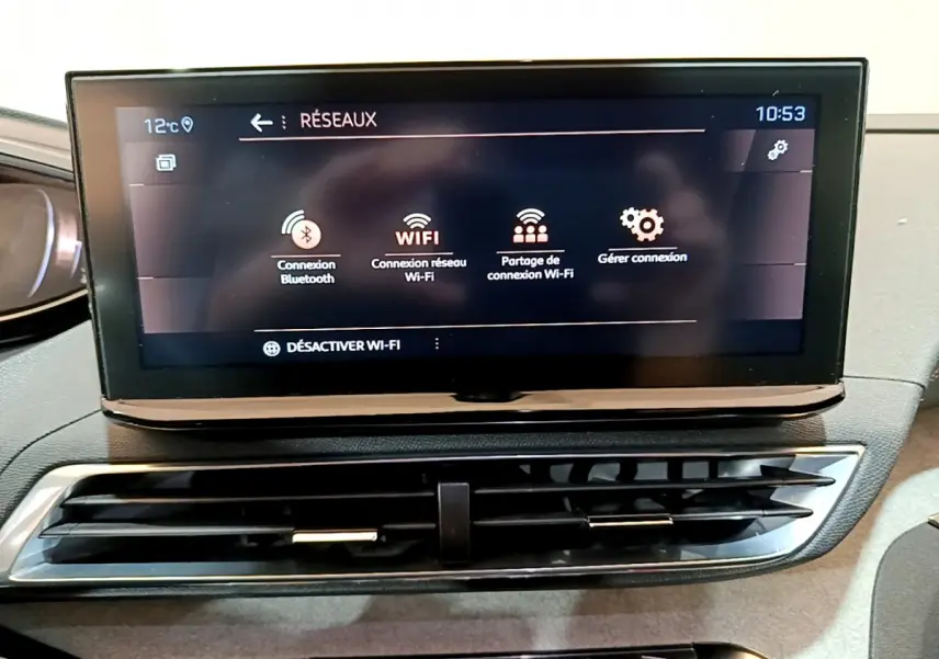 Écran tactile central affichant les options Wi-Fi et Bluetooth sur le tableau de bord du Peugeot 5008 GT bleu 2021
