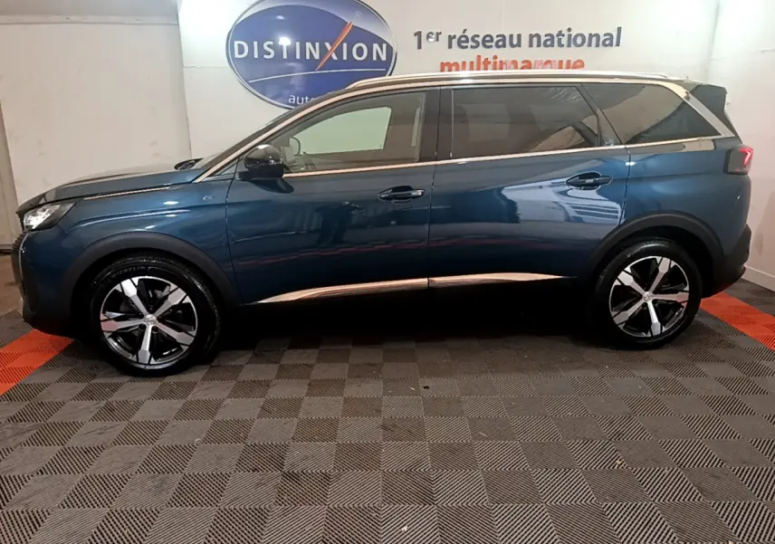 Profil côté gauche du Peugeot 5008 bleu 2021 avec jantes alliage et toit noir en intérieur showroom
