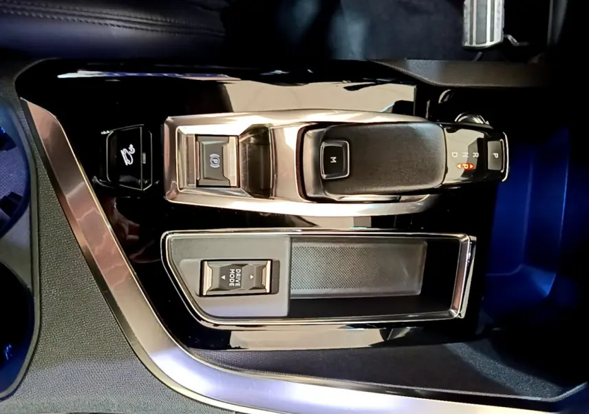 Vue rapprochée de la console centrale noire avec levier de vitesse automatique et bouton Drive Mode du Peugeot 5008 bleu.