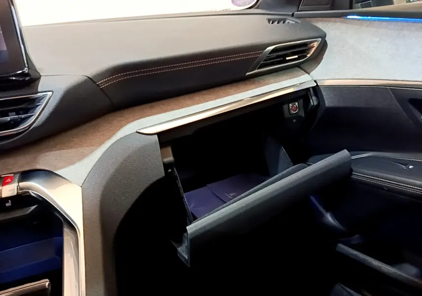 Intérieur du Peugeot 5008 GT 2021, vue côté passager sur la boîte à gants ouverte et tableau de bord noir et gris.