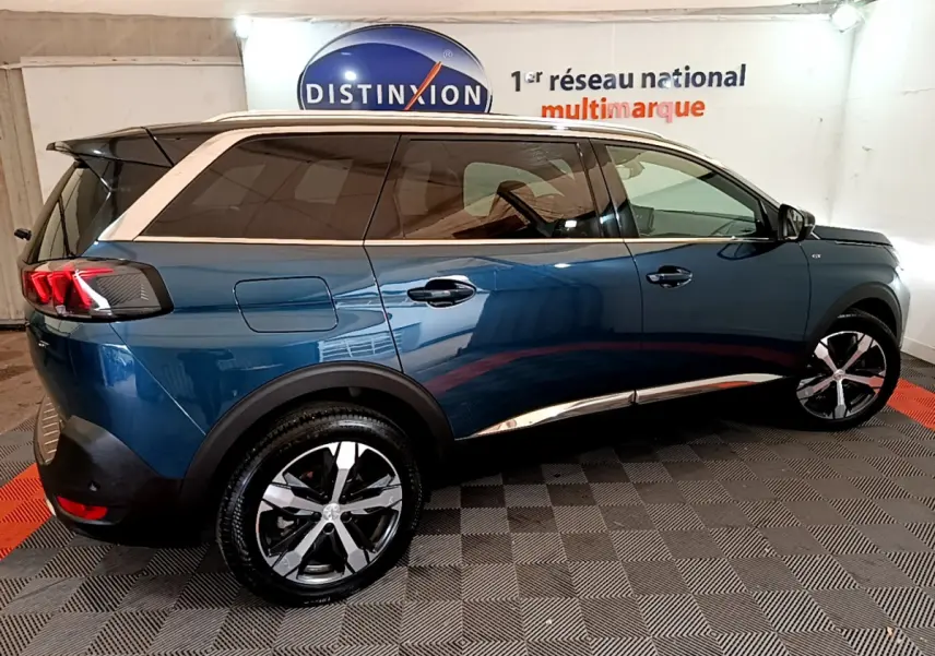 Vue latérale droite d'un Peugeot 5008 bleu 2021 avec toit blanc et jantes alliage distinctives.