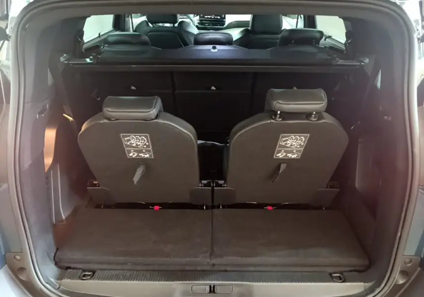 Vue arrière du coffre du Peugeot 5008 bleu, montrant la 3ème rangée de sièges individuels rabattus et amovibles.