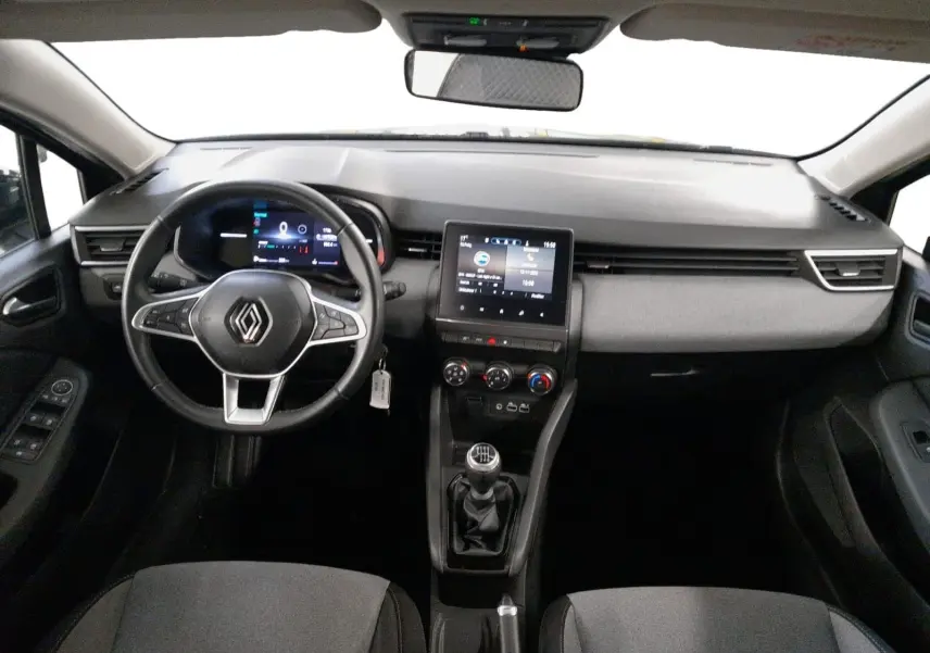 Vue intérieure avant de la Renault Clio V gris schiste, tableau de bord numérique et console centrale avec boîte manuelle.