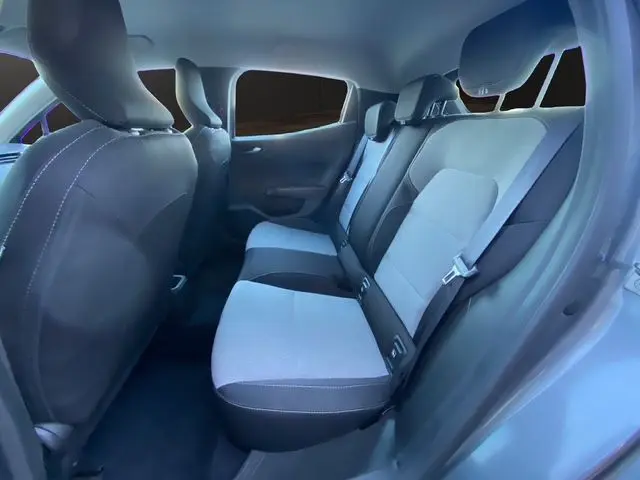 Vue intérieure arrière droite de la Renault Clio V gris schiste, montrant la banquette arrière en textile gris avec appuie-têtes.