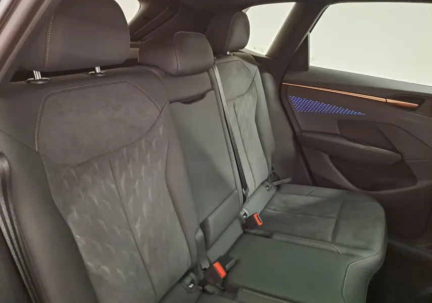 Vue intérieure côté droit des sièges arrière en tissu et cuir noir avec éclairage d'ambiance bleu sur la porte du CUPRA TERRAMAR.