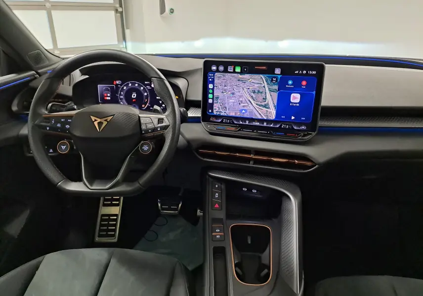 Vue intérieure du tableau de bord et volant de la CUPRA TERRAMAR 2025 avec écran tactile et éclairage bleu d'ambiance.
