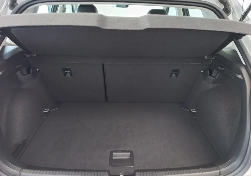 Coffre ouvert vu de l'arrière d'une Volkswagen Polo 1.0 TSI 95 DSG7 Style couleur reflet d'argent, intérieur noir.
