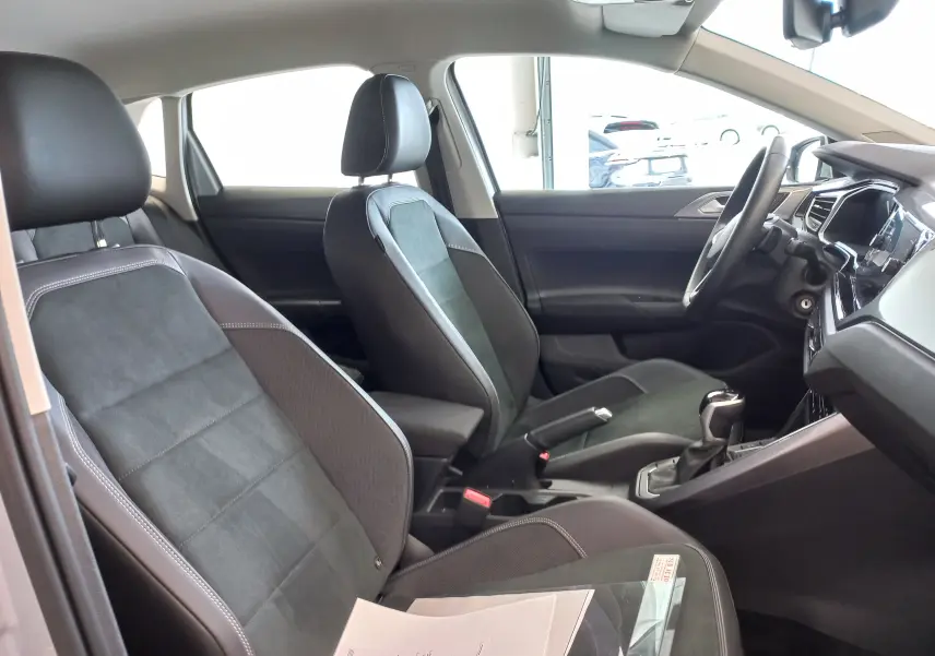 Vue intérieure côté droit du Volkswagen Polo 2026, sièges en tissu noir et console centrale avec levier de vitesse manuel.
