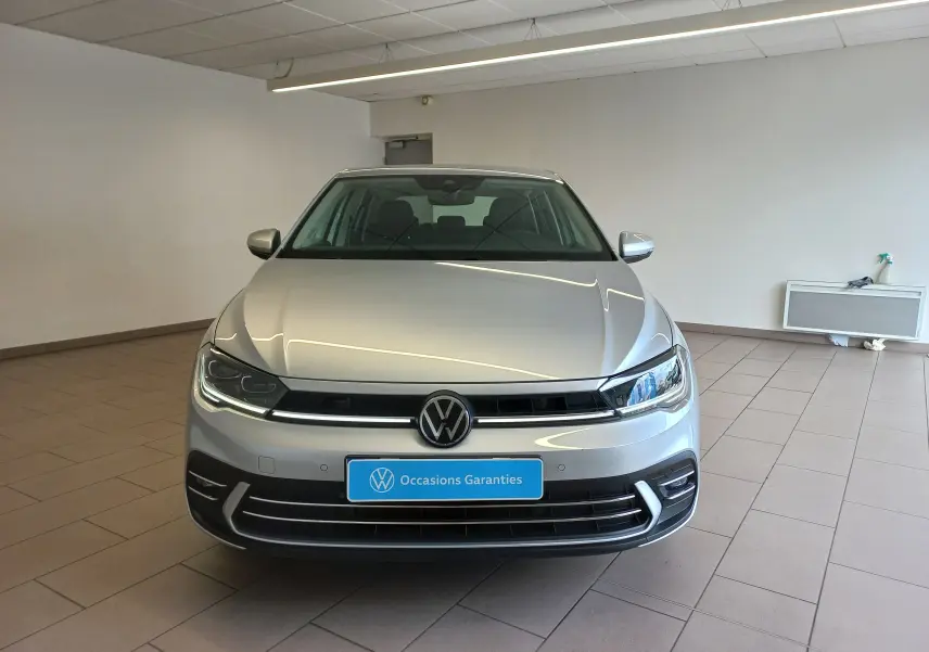 Vue avant d'une Volkswagen Polo 1.0 TSI 95 DSG7 Style couleur reflet d'argent dans un showroom lumineux.