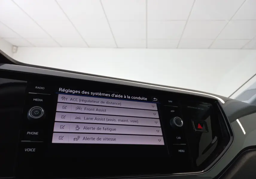 Écran central tactile du Volkswagen Polo 2026 montrant les réglages des aides à la conduite, intérieur noir et gris.