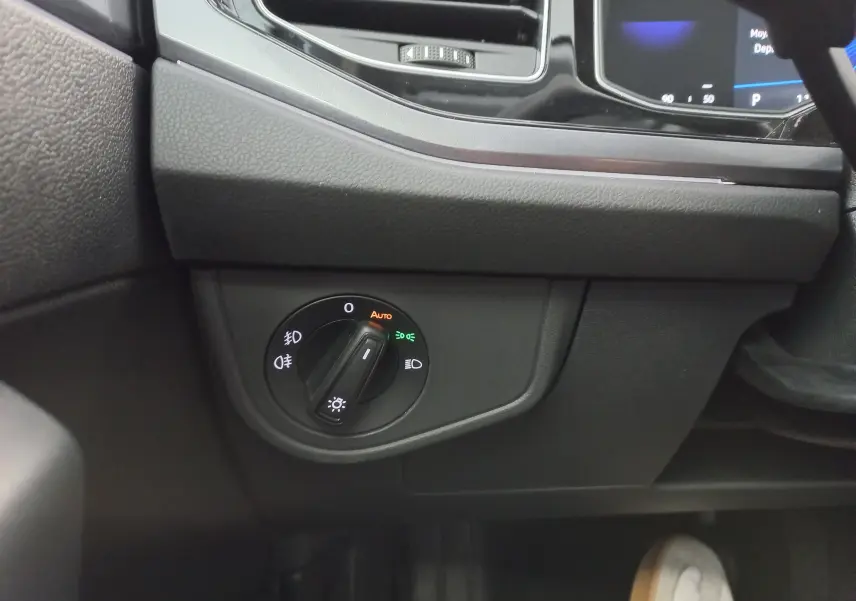 Gros plan sur le bouton de commande des phares à gauche du tableau de bord d'une Volkswagen Polo 2026.