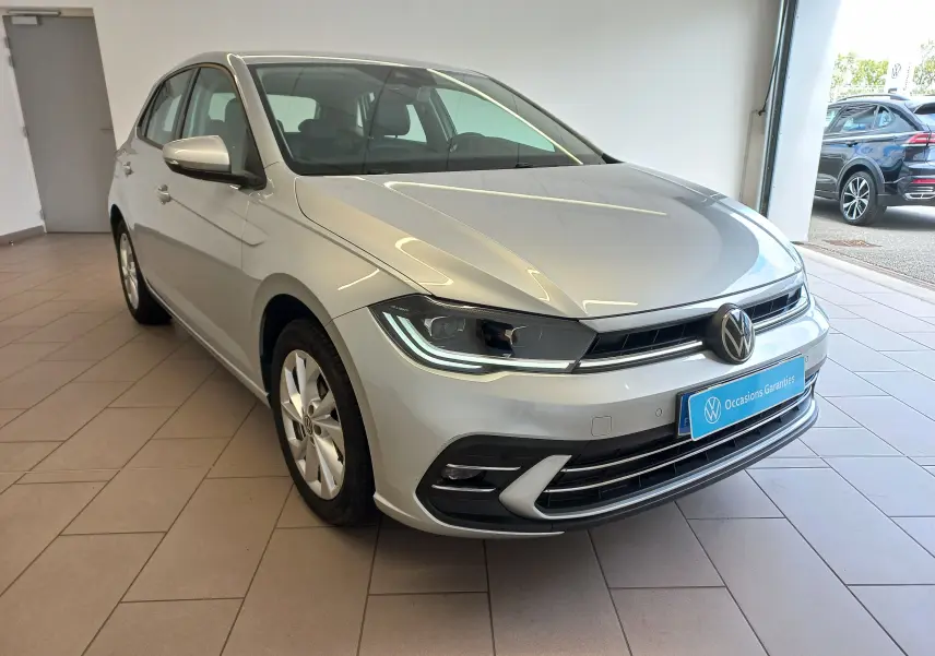 Vue 3/4 avant droite d'une Volkswagen Polo 2026 couleur reflet d'argent, avec phares LED et calandre noire brillante.