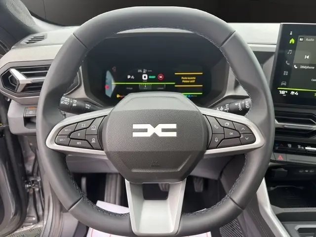 Vue rapprochée du volant cuir synthétique et du combiné numérique du tableau de bord du Dacia Bigster gris foncé 2026.