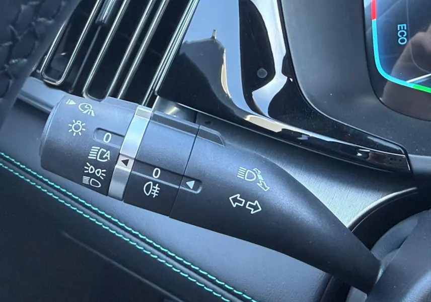 Gros plan sur la commande de clignotants et phares dans l’habitacle du BYD SEAL U 1.5 DM-i 324ch Design AWD.