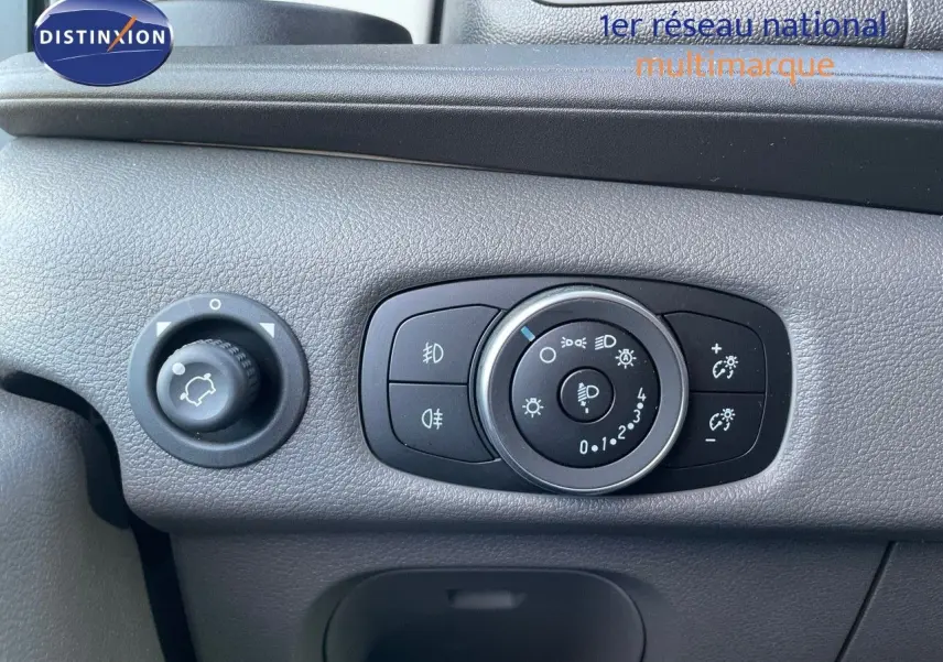 Gros plan sur les commandes d'éclairage du tableau de bord gris du Ford Transit Fourgon blanc 2023.