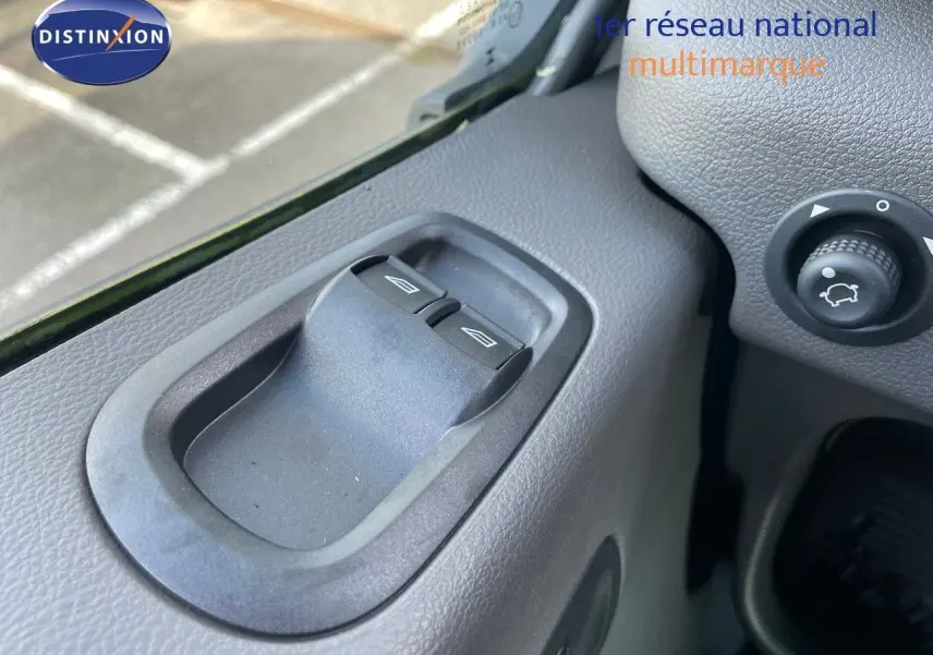 Gros plan sur les commandes des vitres côté gauche d'un Ford Transit Fourgon blanc 2023, intérieur gris.