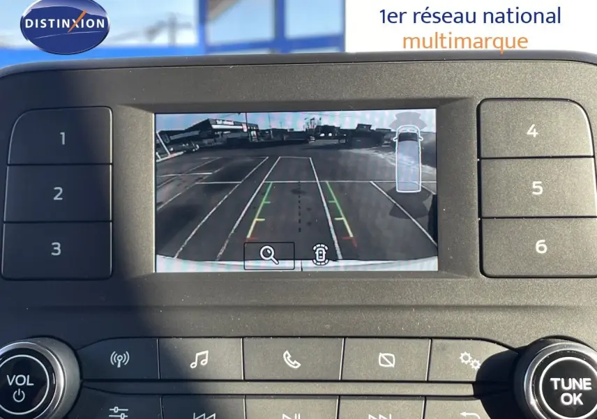 Écran de caméra de recul du Ford Transit Fourgon blanc 2023, affichant un parking vide vu de l'arrière.