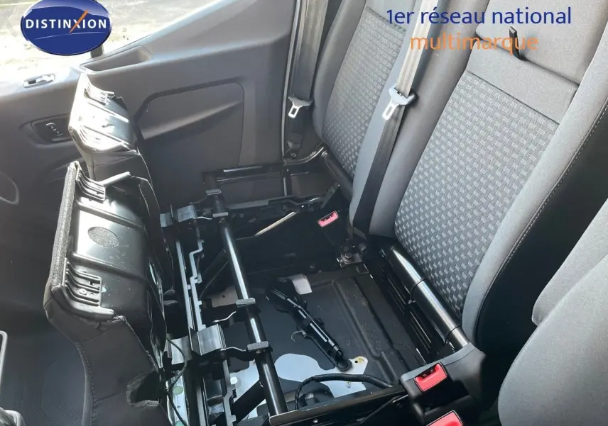 Vue rapprochée de l'intérieur du Ford Transit Fourgon 2023 montrant la banquette arrière grise avec assise relevée et structure métallique visible.