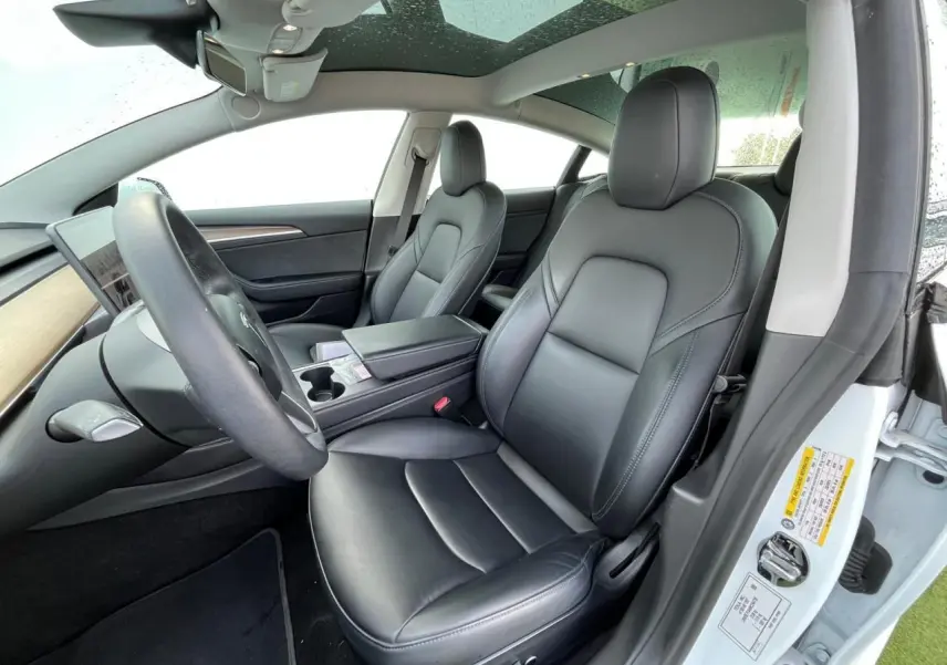 Intérieur noir premium de la Tesla Model 3 Standard Plus 2022, vue côté conducteur avec toit panoramique en verre.