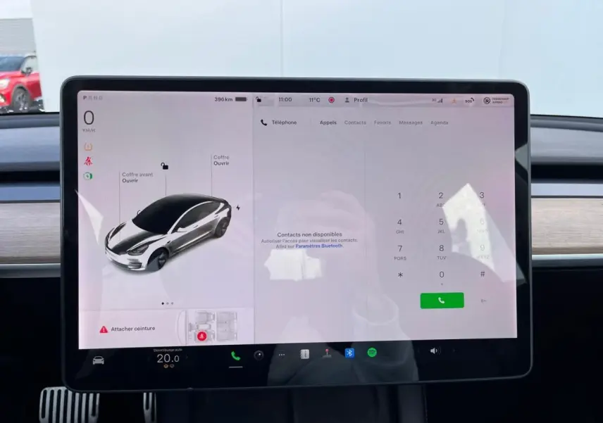 Écran tactile central de la Tesla Model 3 blanc 2022 affichant le tableau de bord et les commandes du véhicule.
