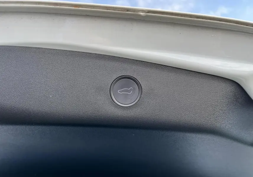 Bouton de déverrouillage du coffre intégré sur la partie intérieure du hayon blanc d'une Tesla Model 3 Standard Plus 2022.