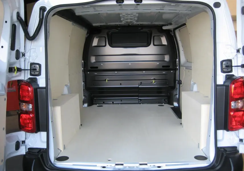 Vue arrière intérieure du Peugeot Expert Fourgon blanc 2025, montrant l'espace de chargement avec revêtement bois clair.