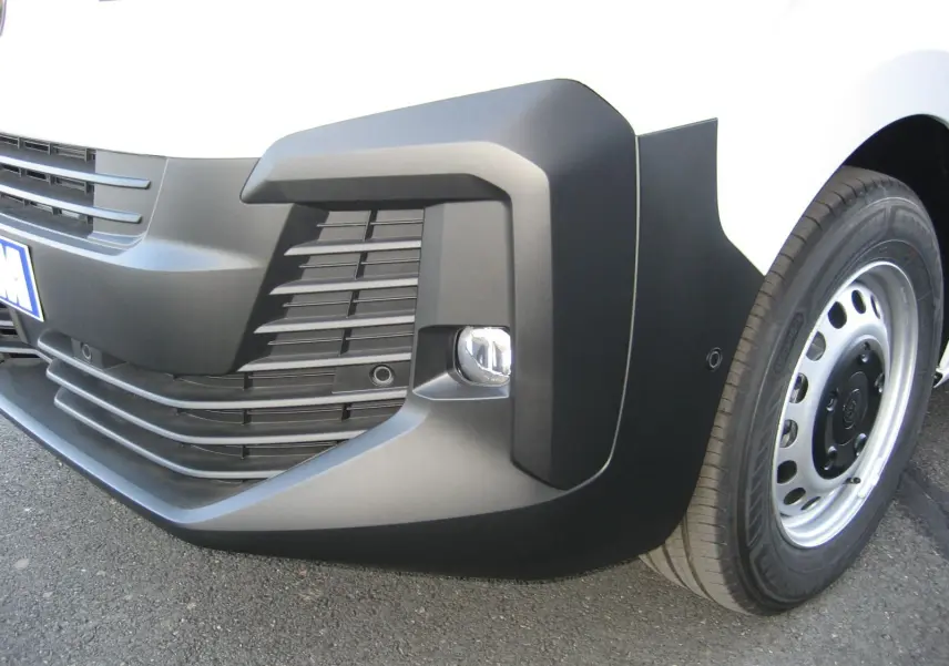 Gros plan sur le pare-chocs avant droit blanc du Peugeot Expert Fourgon avec antibrouillard et jante acier.