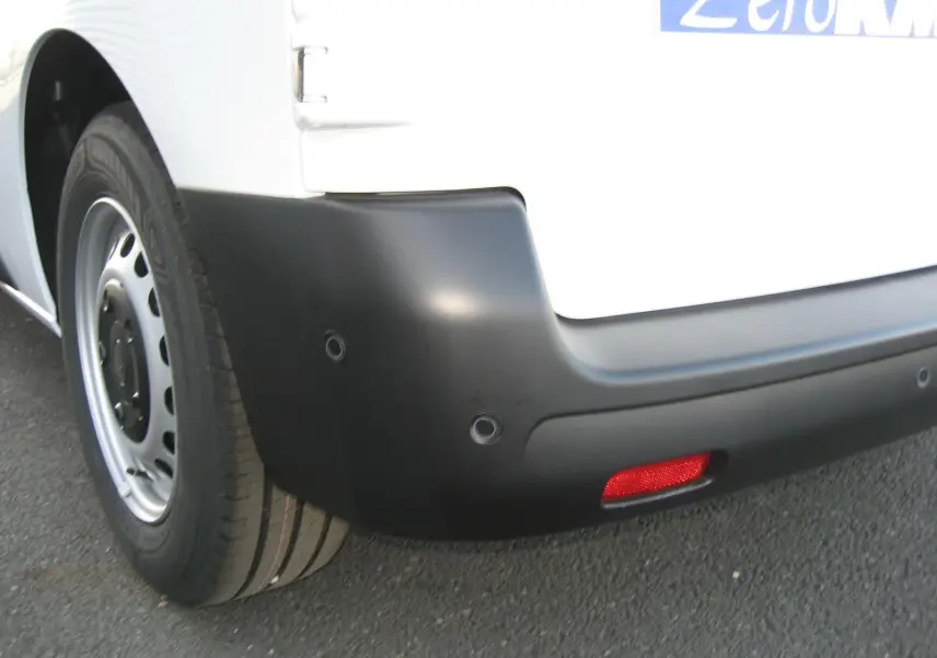 Gros plan sur le pare-chocs arrière noir et la roue côté gauche du Peugeot Expert Fourgon blanc 2025.