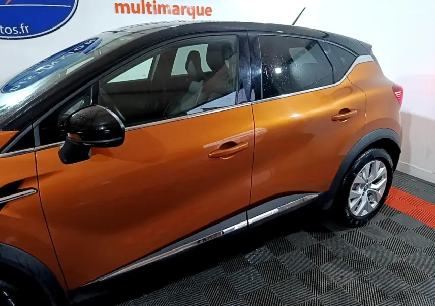 Vue de profil côté gauche d'un Renault Captur Intens jaune avec toit noir et jantes alliage.