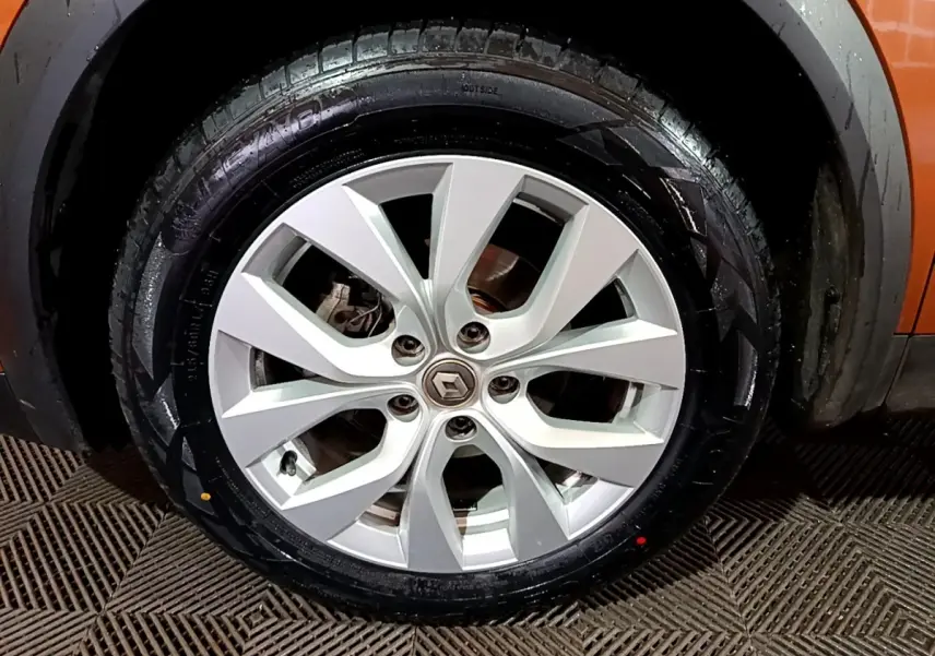 Gros plan sur la roue avant droite du Renault Captur jaune, mettant en valeur la jante alliage argentée et le pneu.