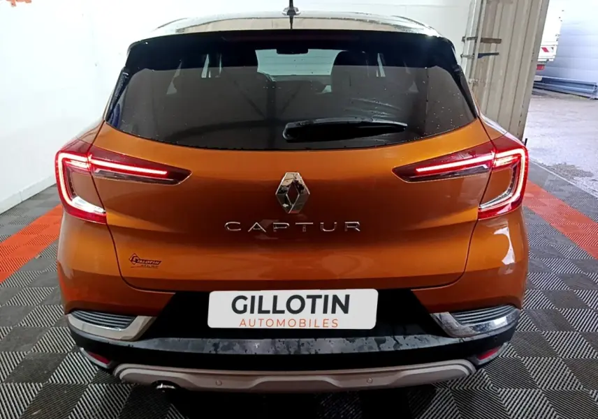 Vue arrière d'un Renault Captur jaune avec feux arrière LED allumés dans un garage.