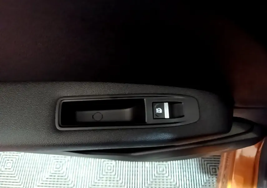 Gros plan sur le bouton de verrouillage des portes côté intérieur d'une Renault Captur jaune, version Intens 2020.