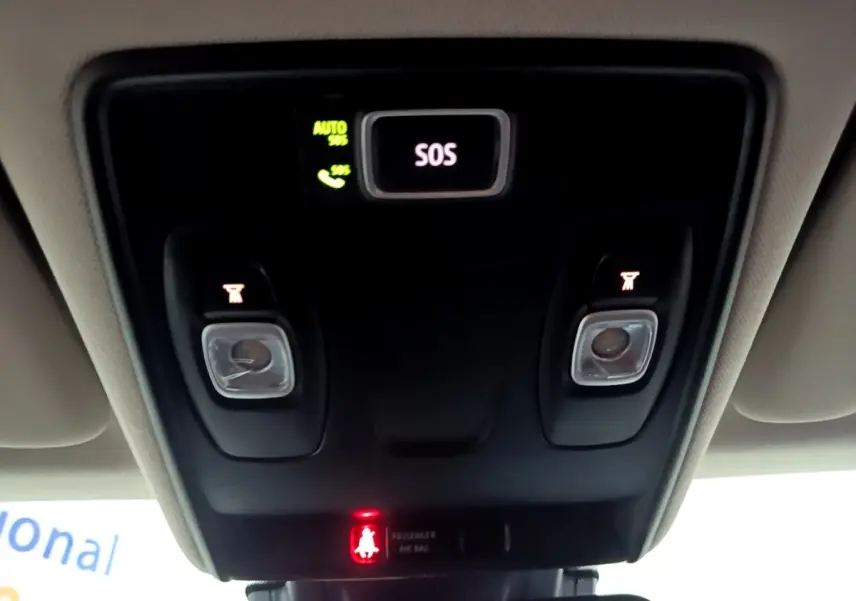 Vue en contre-plongée du plafonnier intérieur noir avec boutons d’éclairage et alerte SOS allumée dans un Renault Captur jaune.