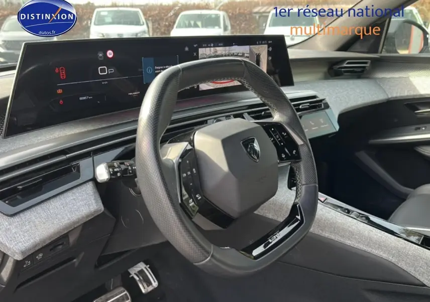 Vue intérieure côté conducteur du Peugeot 3008 gris Artense avec volant multifonction et tableau de bord numérique large.