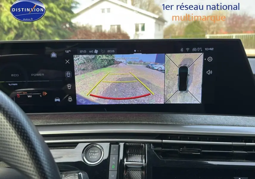 Vue intérieure du tableau de bord du Peugeot 3008 2025 avec écran tactile affichant la caméra de recul et commandes autour du bouton start/stop.