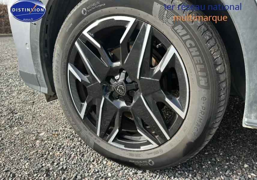 Gros plan sur la roue avant gauche du Peugeot 3008 gris Artense avec jante alu au design moderne.