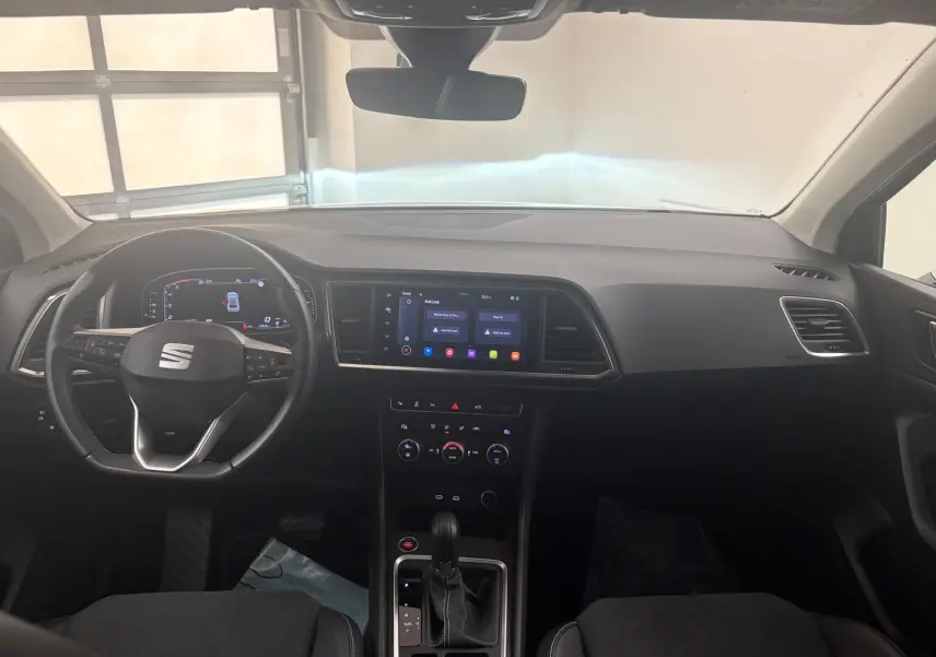 Vue intérieure avant du tableau de bord du SEAT Ateca 2.0 TDI 150 DSG7, avec écran tactile central et volant multifonction.