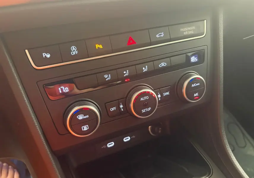 Vue rapprochée de la console centrale du SEAT Ateca 2025, montrant les commandes de climatisation et les ports USB.