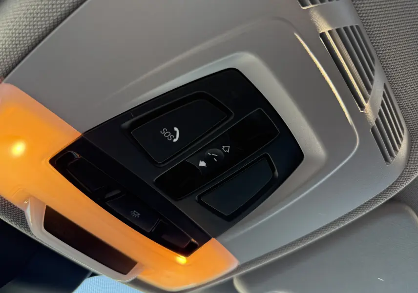 Vue en gros plan du panneau de commandes de toit intérieur avec éclairage orange dans une BMW X1 blanche de 2018.