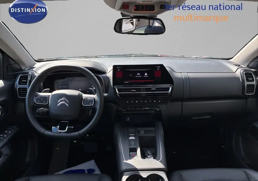 Vue intérieure frontale du tableau de bord noir du Citroën C5 Aircross 2025 avec écran tactile et volant multifonction.