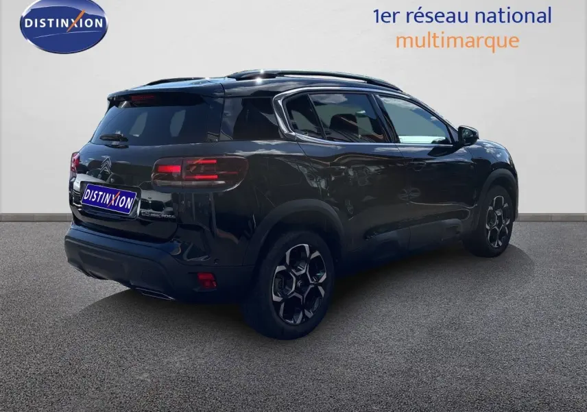 Vue 3/4 arrière droite du Citroën C5 Aircross noir Perla Nera, avec jantes distinctives et toit panoramique.