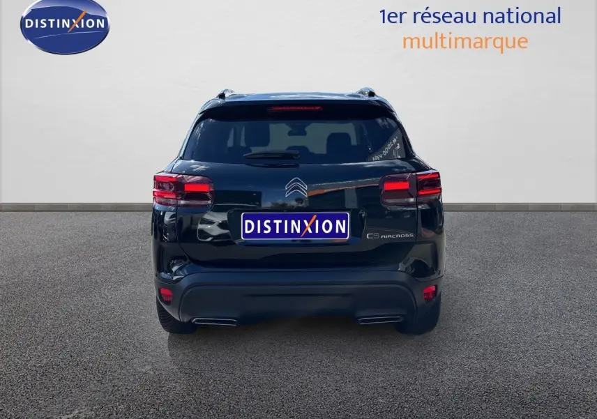 Vue arrière d'un Citroën C5 Aircross noir Perla Nera Metal, mettant en valeur ses feux arrière et son design compact.