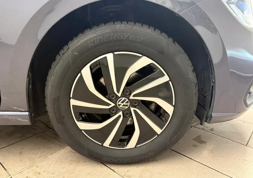 Gros plan sur la roue avant droite d'une Volkswagen Polo gris cendre 2024 avec jante alliage noire et argentée.